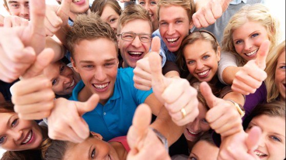 Group of successful students giving the thumbs up