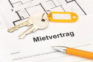 Mietvertrag mit orangem Schlüsselbund und Kugelschreiber